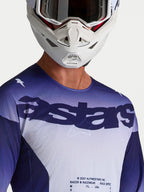 Alpinestars Racer Air Amber Trikot in Blau und Weiß, Motocross-Mesh-Jersey mit Astars-Logo am Model mit Helm.