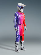 Motocross-Fahrer in kompletter Rennausrüstung, 2026 Fluid Apex Trikot und Hose mit einem lebendigen Farbverlauf in Lila, Pink und Orange, weißer Helm mit blauer Brille, weiß-schwarze Stiefel und weiße Handschuhe, abgestimmtes Outfit für Offroad-Motocross.
