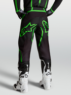 Alpinestars Fluid Apex V2 Hose, Motocross- und Offroad-Hose für Herren, Schwarz und Fluogrün, Rückansicht am Model mit weißen Tech 7 Stiefeln