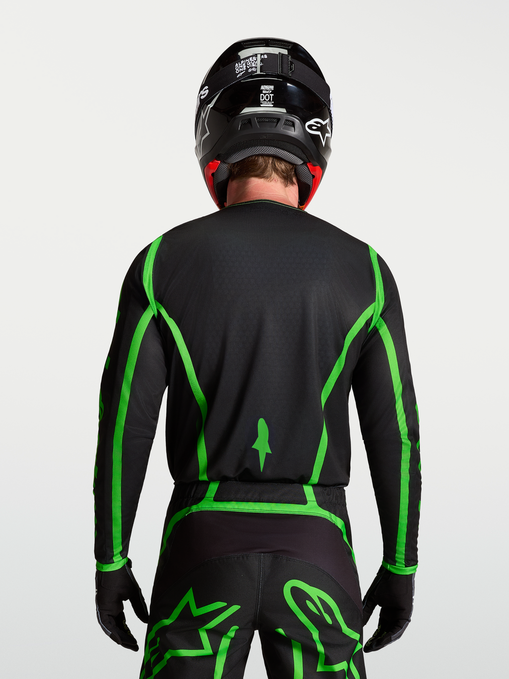 Alpinestars Fluid Apex V2 Trikot für Motocross, Schwarz und fluoreszierendes Grün, Rückansicht mit verlängertem Rückenteil.