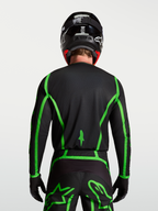 Alpinestars Fluid Apex V2 Trikot für Motocross, Schwarz und fluoreszierendes Grün, Rückansicht mit verlängertem Rückenteil.