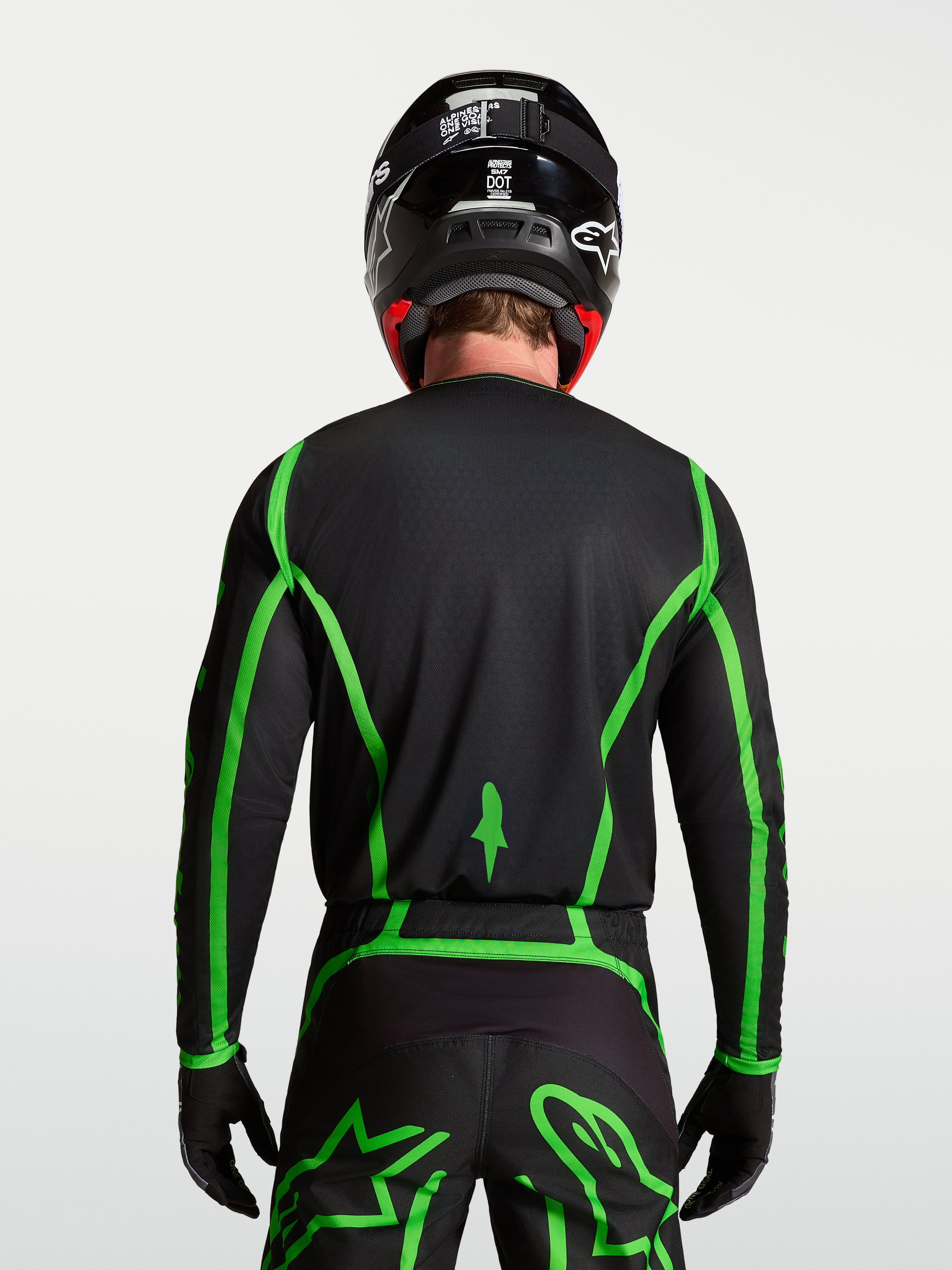 Alpinestars Fluid Apex V2 Trikot für Motocross, Schwarz und fluoreszierendes Grün, Rückansicht mit verlängertem Rückenteil.