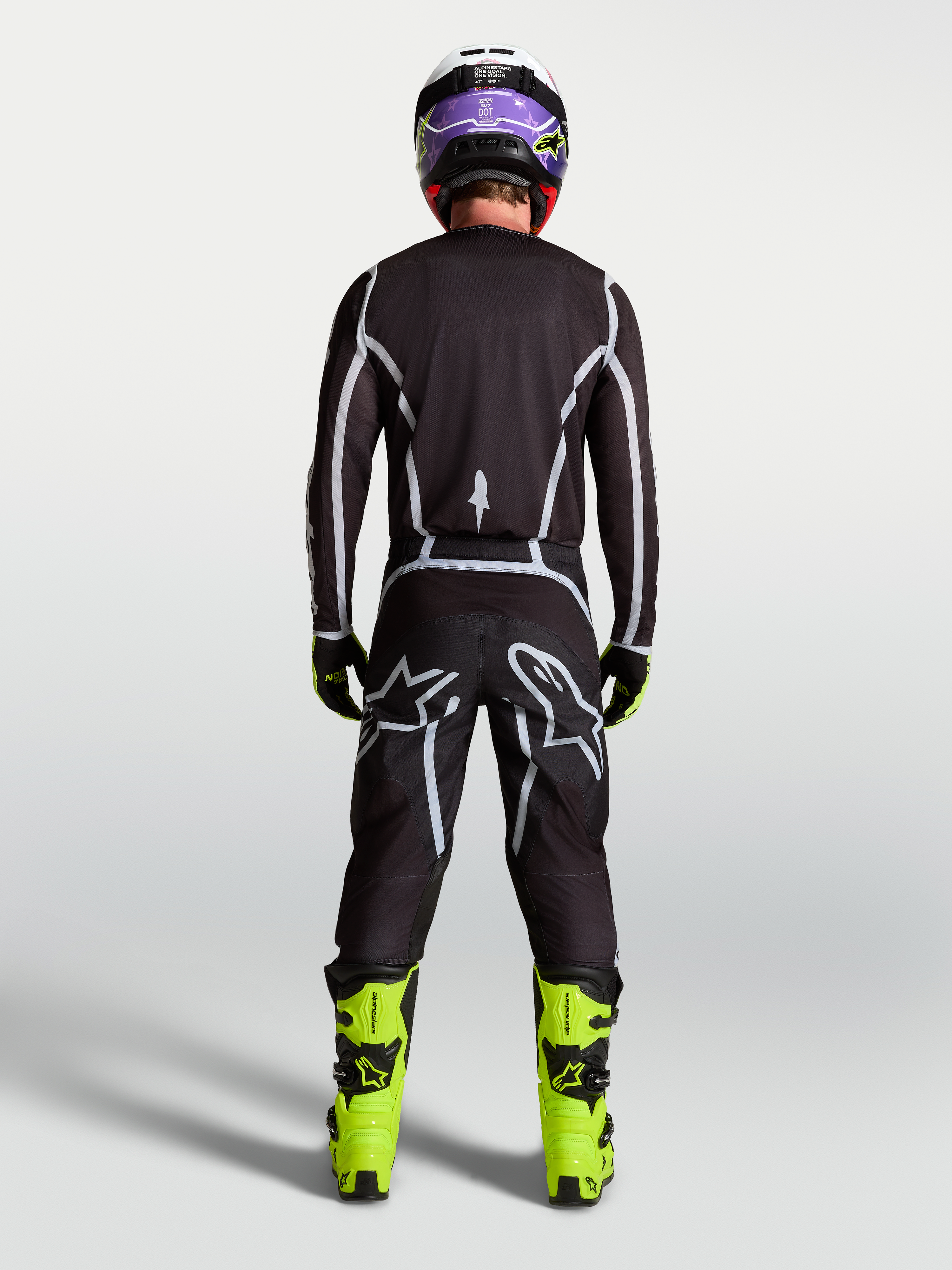 Alpinestars Fluid Apex V2 Trikot, Motocross-Ausrüstung für Herren, Schwarz und Silber, Rückansicht am Fahrer in kompletter Rennausrüstung.