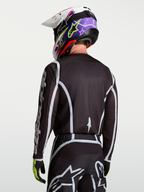 Alpinestars Fluid Apex V2 Trikot, Motocross-Oberteil für Herren, Rückansicht in Schwarz und Silber, feuchtigkeitsableitendes Polygewebe mit ergonomischem Schnitt.