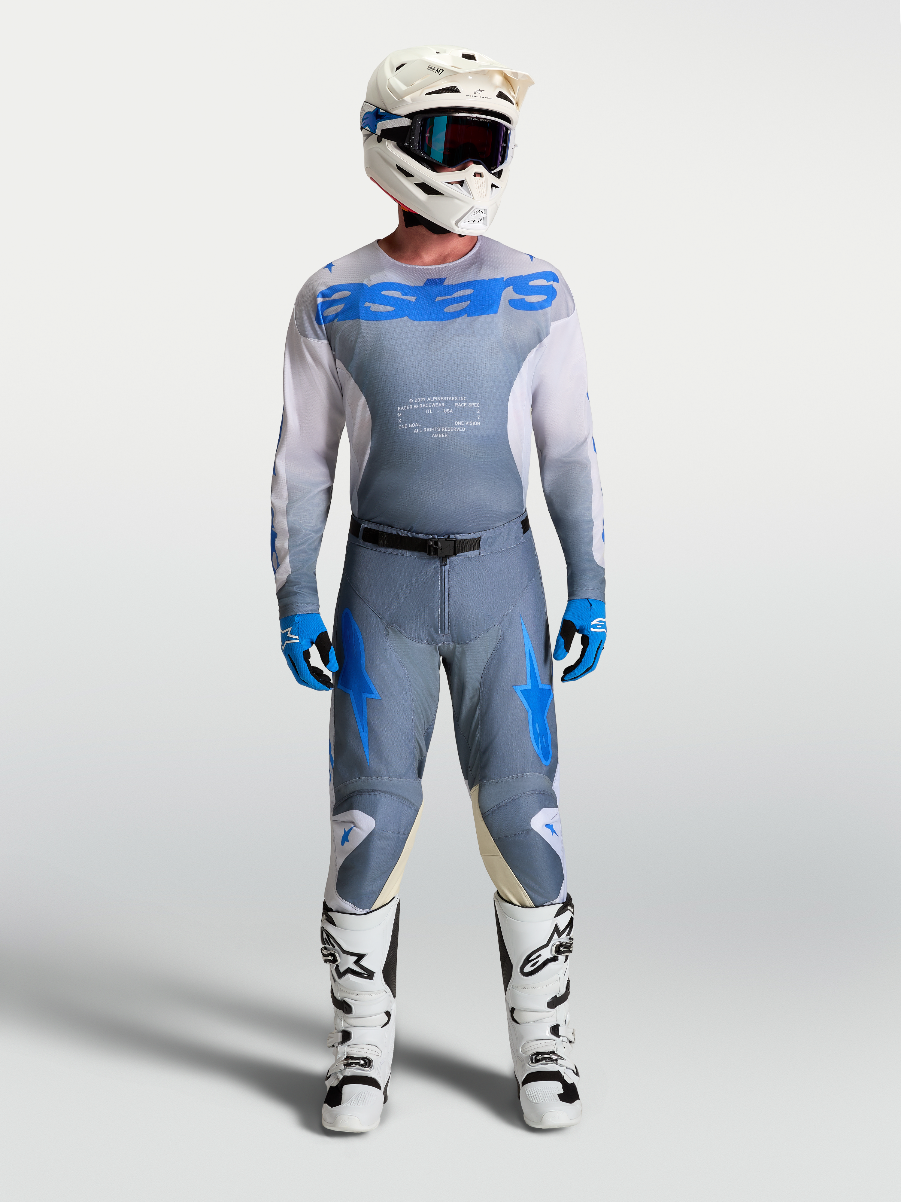 Alpinestars Racer Amber Trikot und Gear Set, Herren-Motocross-Ausrüstung, Aschgrau und UCLA-Blau, mit weißem Helm und Stiefeln.