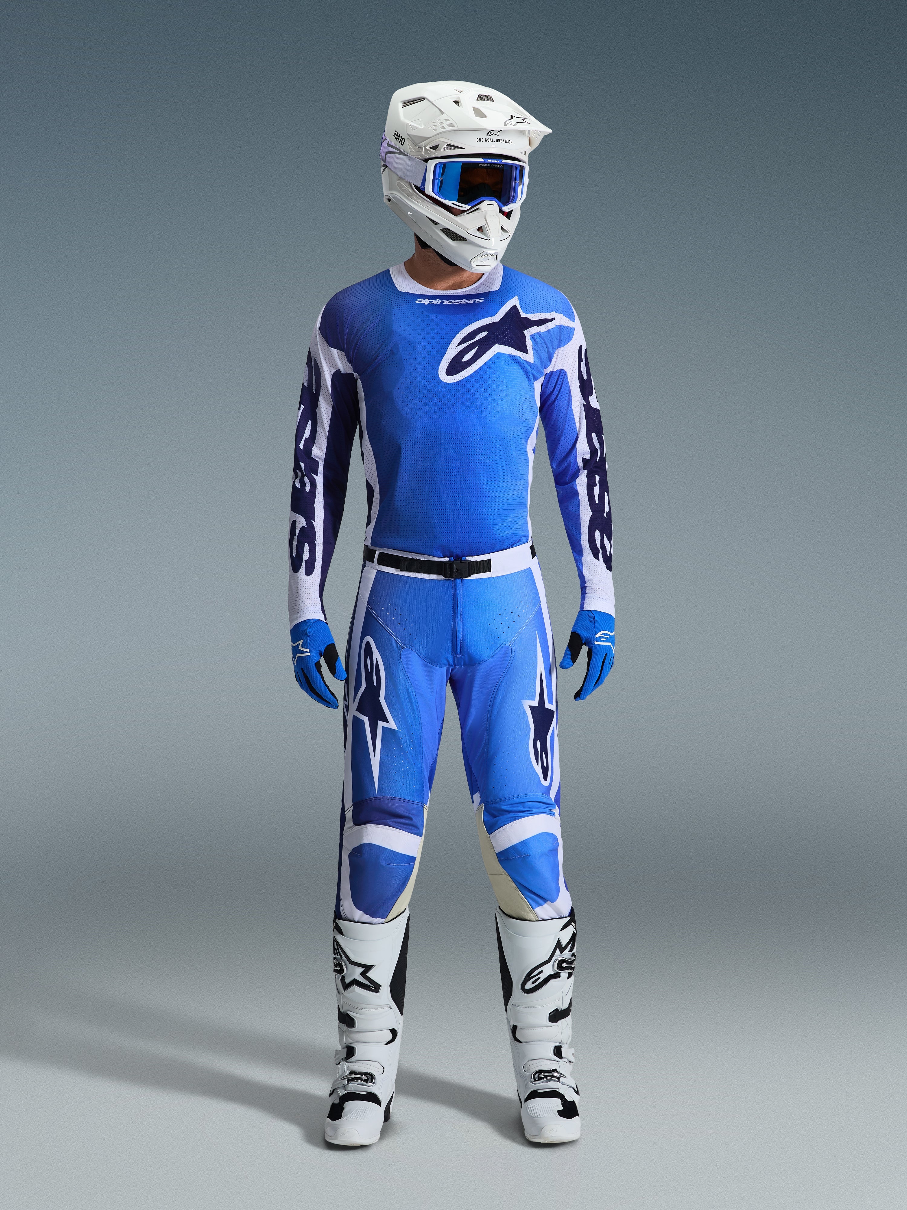 Motocross rider wearing Alpinestars 2026 Racer Air Portl Jersey in Ucla Blue White, paired with matching blue motocross pants, a white helmet with blue goggles, blue gloves, and white boots, complete professional gear set for off-road racing