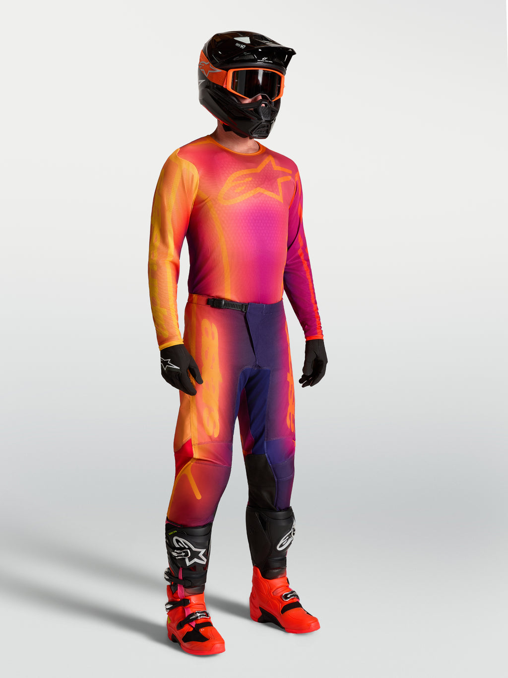 Alpinestars Fluid Kepler Trikot, Motocross-Trikot in Lila und Orange, atmungsaktives Material, getragen mit MX-Ausrüstung.