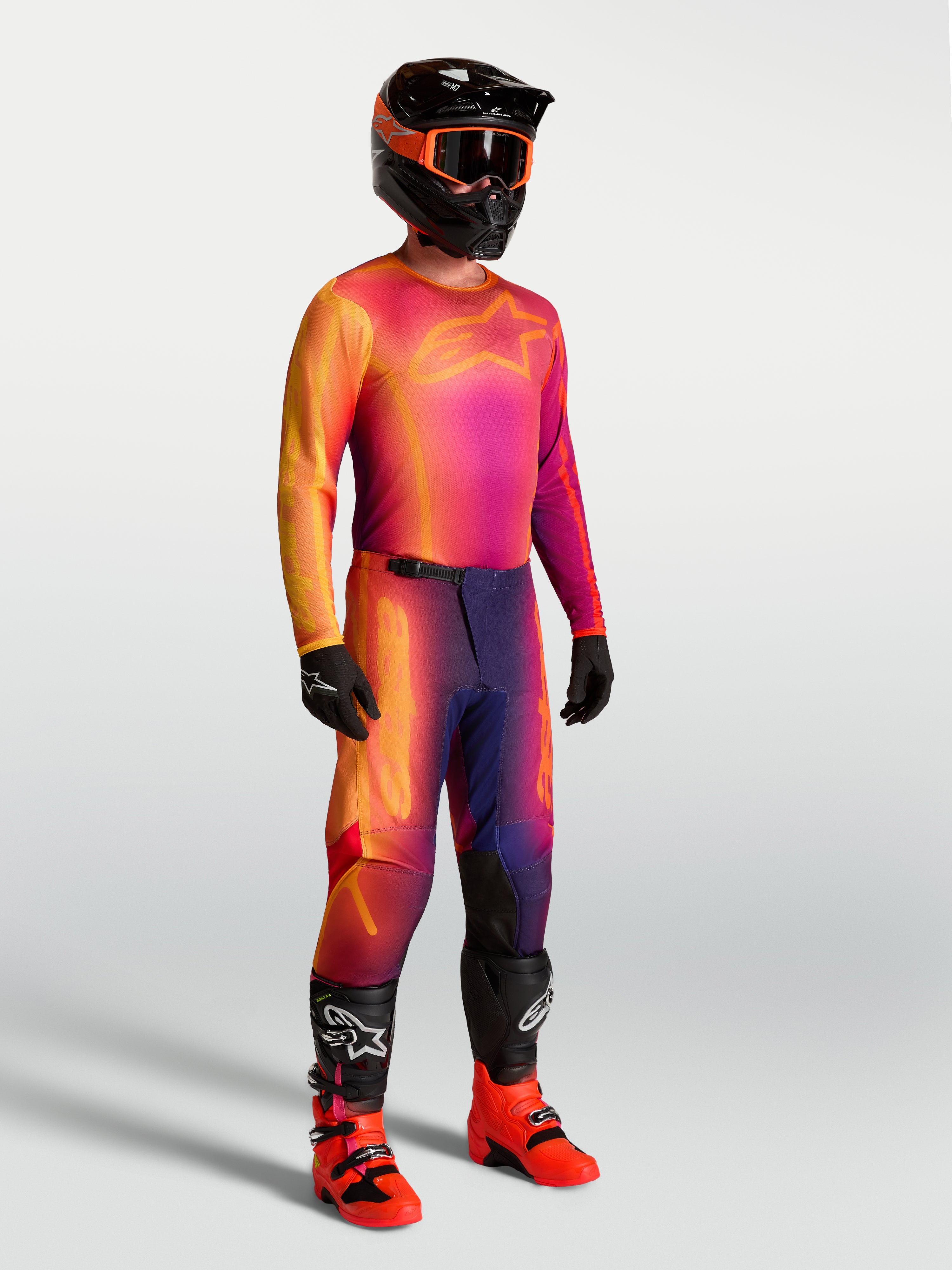 Alpinestars Fluid Kepler Trikot, Motocross-Trikot in Lila und Orange, atmungsaktives Material, getragen mit MX-Ausrüstung.
