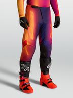 Alpinestars Fluid Kepler Hose, Offroad-Motocross-Hose in Lila und Orange, sportliche Passform, getragen mit Tech-Stiefeln und Handschuhen.