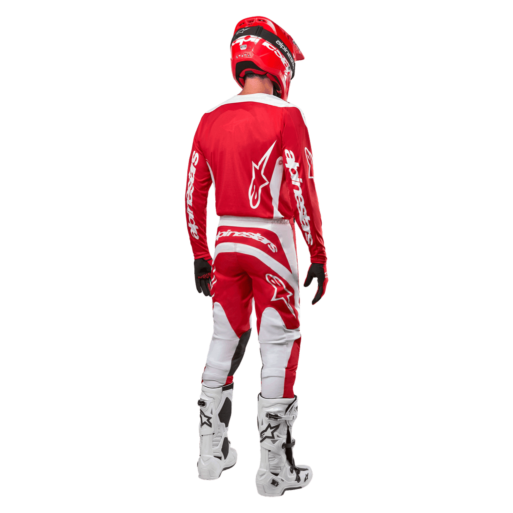 Rückansicht eines Motocross-Fahrers im Alpinestars 2024 Fluid Lurv Trikot in Mars Red White, kombiniert mit passender rot-weißer Hose, weißen Offroad-Stiefeln und einem roten Helm; zeigt das Rückendesign und das Alpinestars-Branding.