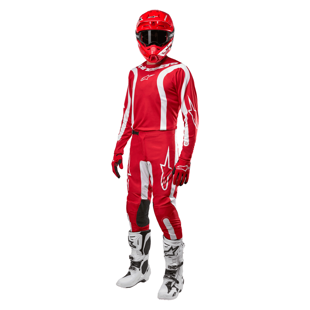 Motocross-Fahrer in kompletter Rennausrüstung, Alpinestars 2024 Fluid Lurv Jersey in Mars-Rot und Weiß, passende rote Hose mit weißen Akzenten, roter Helm, rote Handschuhe und weiß-schwarze Stiefel, abgestimmtes Outfit für den Offroad-Rennsport