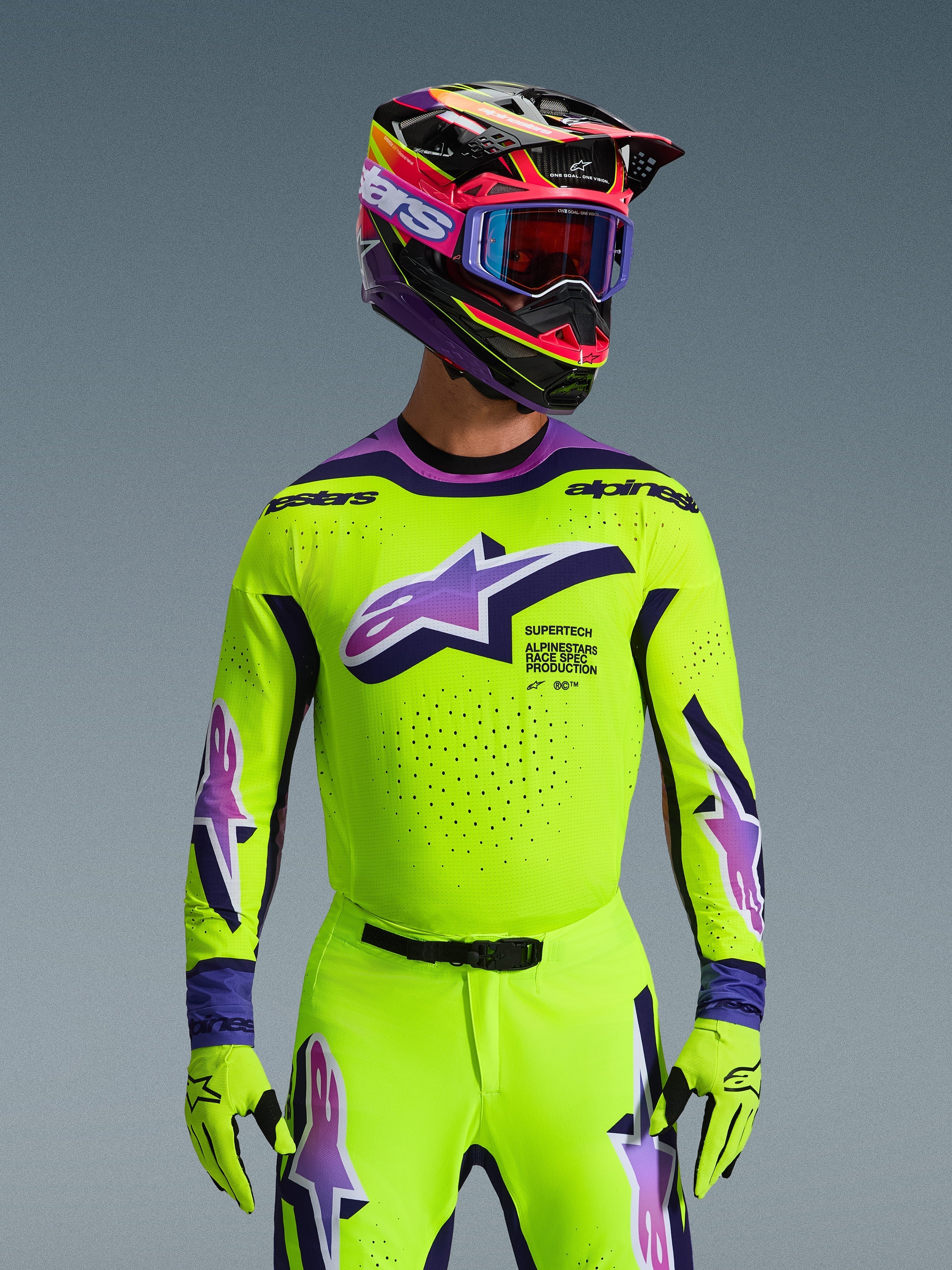 Alpinestars 2026 Supertech Vista Jersey, Motocross-Trikot, leuchtendes Neongelb mit lila und schwarzen Akzenten, getragen mit passendem Motocross-Helm, Brille und Handschuhen, athletische Profi-Passform für den Offroad-Rennsport