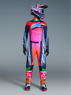 Alpinestars Limited Edition Supertech Records Gear Set, komplette Motocross-Rennausrüstung mit dunkelblauem Trikot und Hose mit leuchtend pinken und orangen Splatter-Mustern, passender Helm, lila Brille und weiße Stiefel mit pinken Akzenten, professionelle Ausrüstung in athletischer Passform für Offroad-Performance