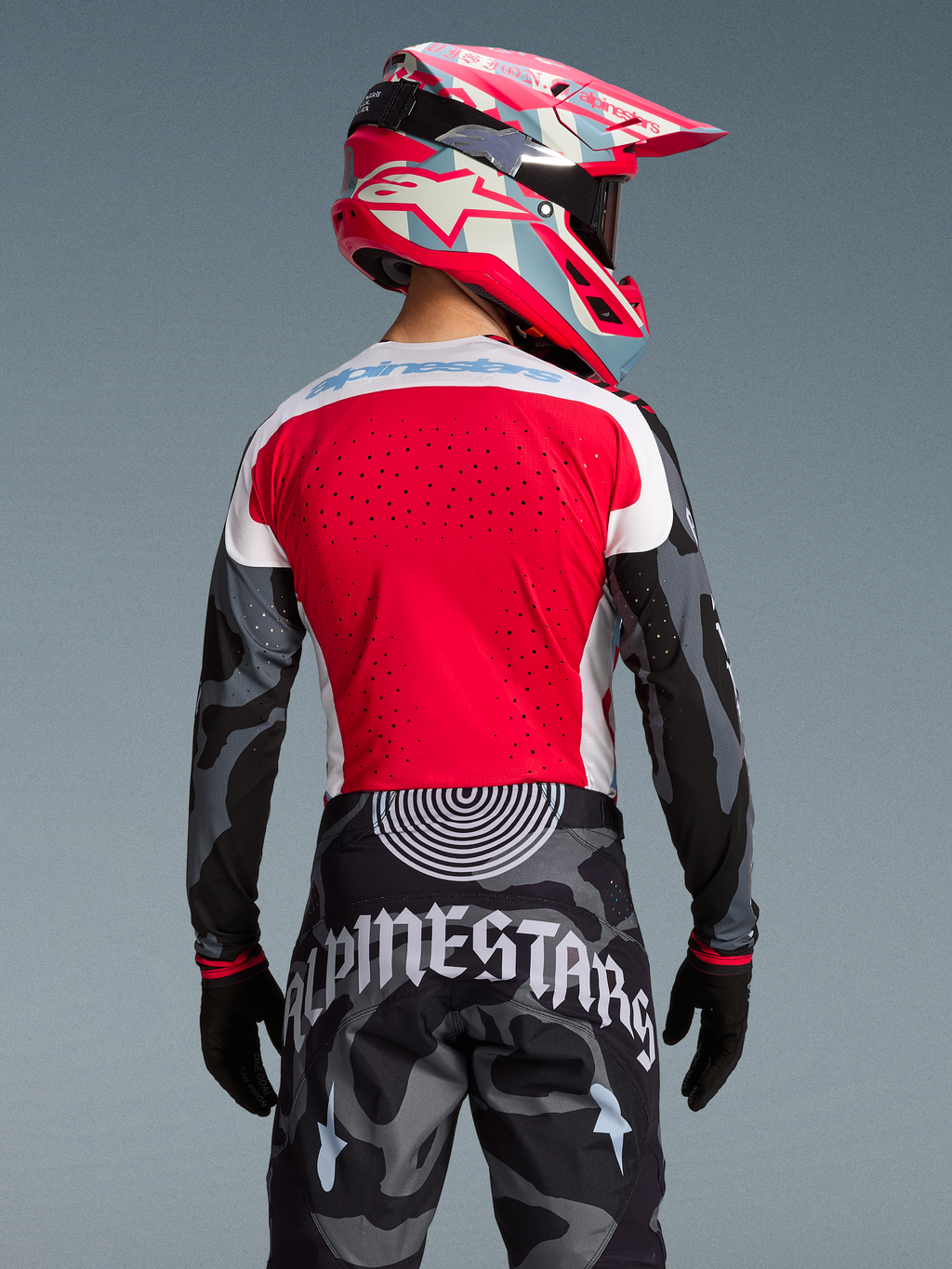 Rückansicht des Techstar Trikots Beast Coast, rot-graues Camouflage-Design mit passender Hose und pinkem Helm.