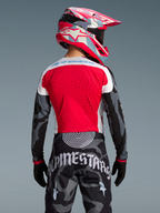 Rückansicht des Techstar Trikots Beast Coast, rot-graues Camouflage-Design mit passender Hose und pinkem Helm.