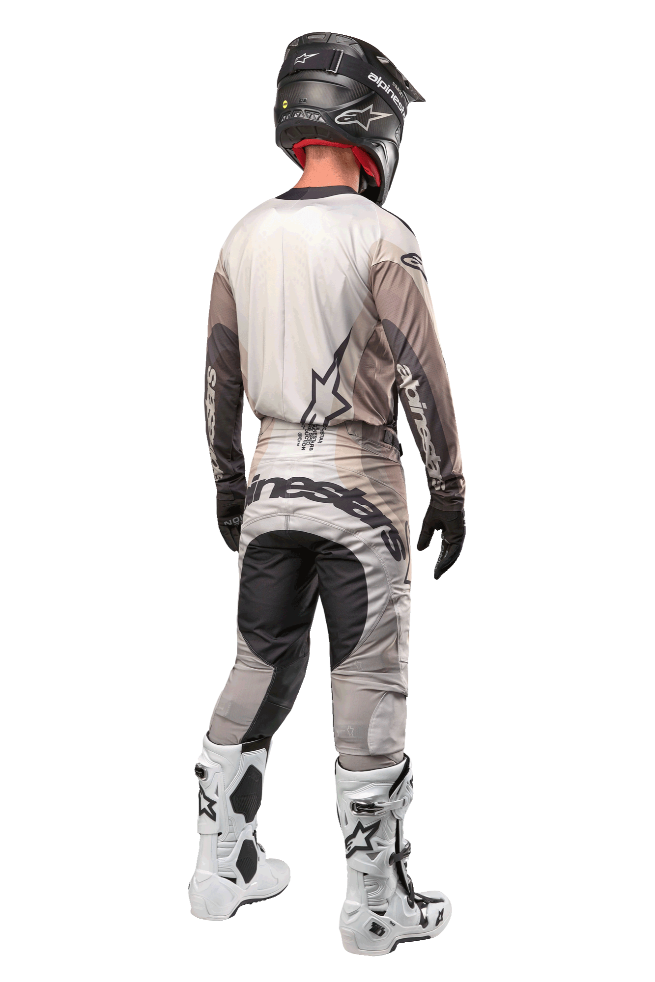 Motocross rider from the back wearing the 2024 Techstar Pneuma Jersey in Dark Sand Iron Dust Gray, matching motocross pants with bold branding, black helmet, and white racing boots, coordinated professional off-road gear.