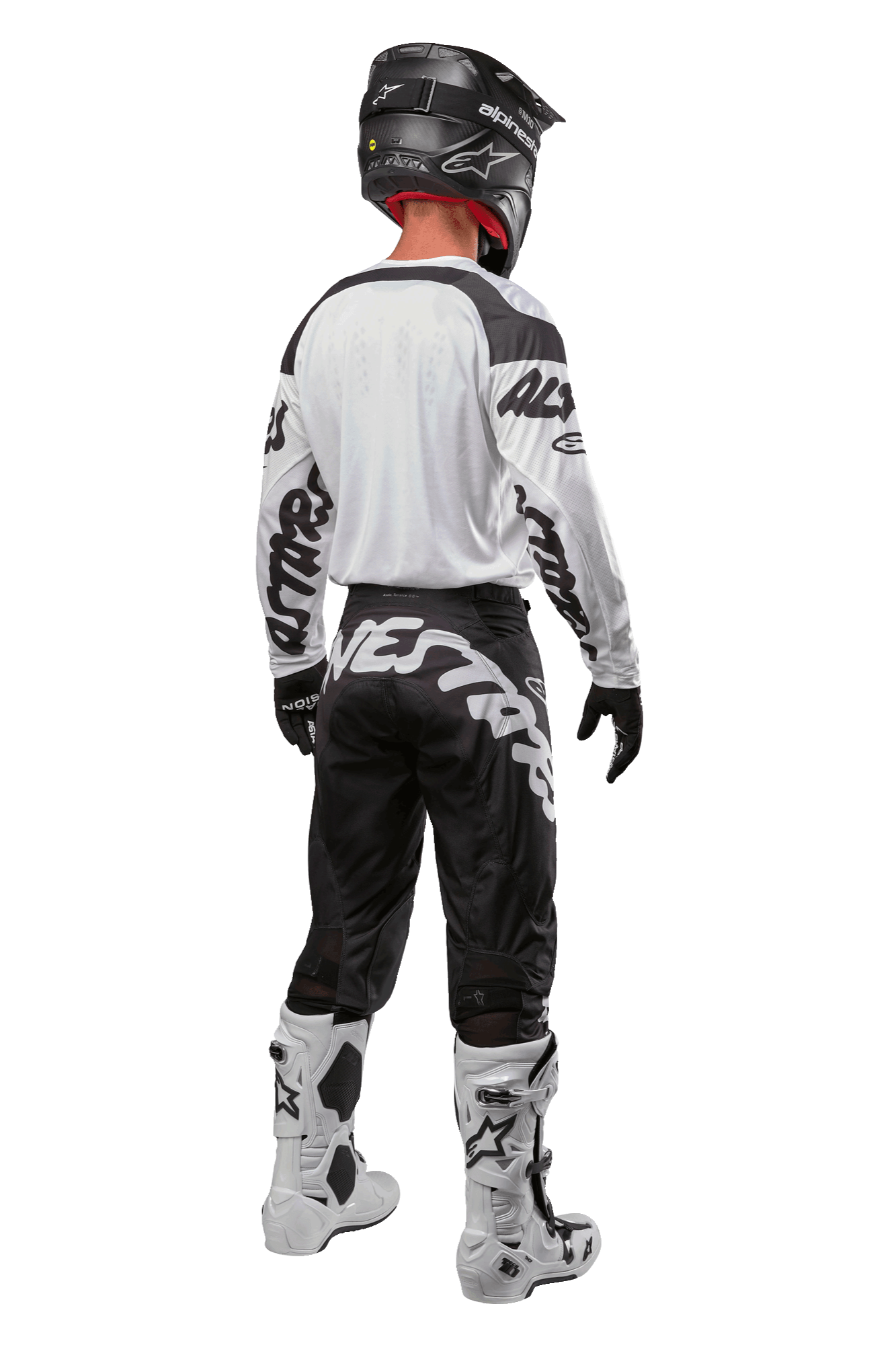 Alpinestars 2024 Racer Hana Trikot, Rückansicht eines Motocross-Fahrers, Weiß und Schwarz, weißes Trikot mit schwarzen Grafiken an den Ärmeln, kombiniert mit einer schwarzen Hose mit weißem Alpinestars-Schriftzug am Gesäß, schwarzer Helm und weiß-schwarze Stiefel, abgestimmte Offroad-Rennausrüstung