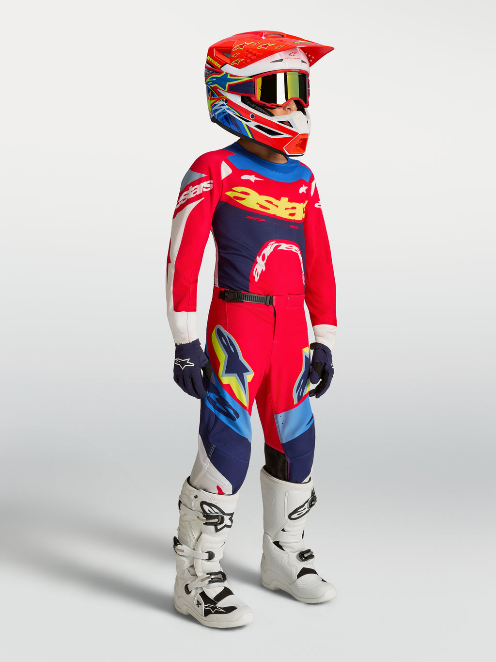 Alpinestars Supertech Dyna Jugend-Trikot und Gear-Set 2027 in Rot und Navy-Blau für Motocross mit weißen Stiefeln.