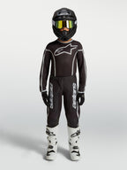 Alpinestars Fluid Apex V2 Jugend-Trikot und Gear Set, Motocross-Outfit in Schwarz und Silber mit weißen Stiefeln.