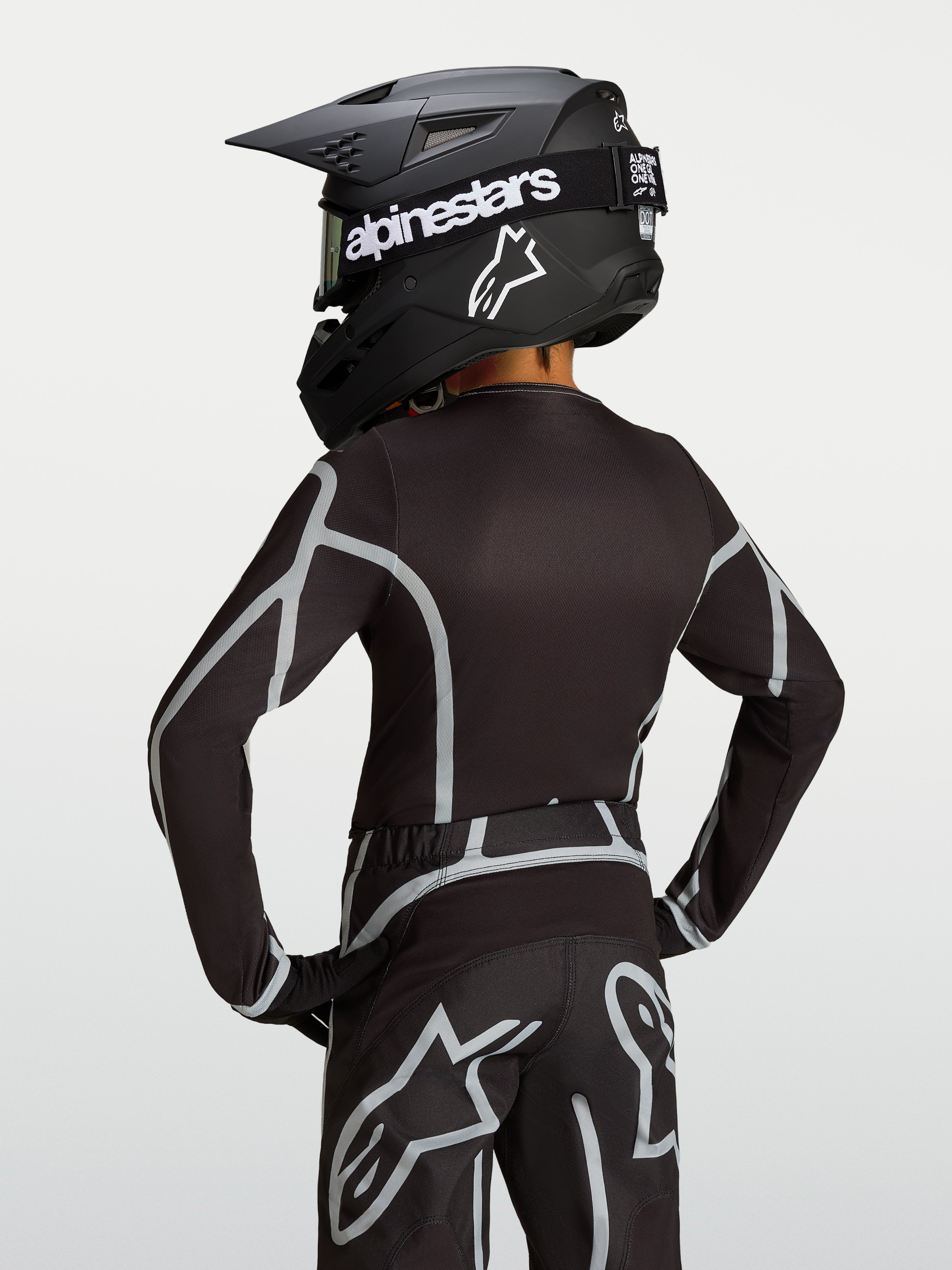 Alpinestars Fluid Apex V2 Jugend-Trikot, Motocross-Ausrüstung in Schwarz und Silber, Rückansicht mit ergonomischem Schnitt.