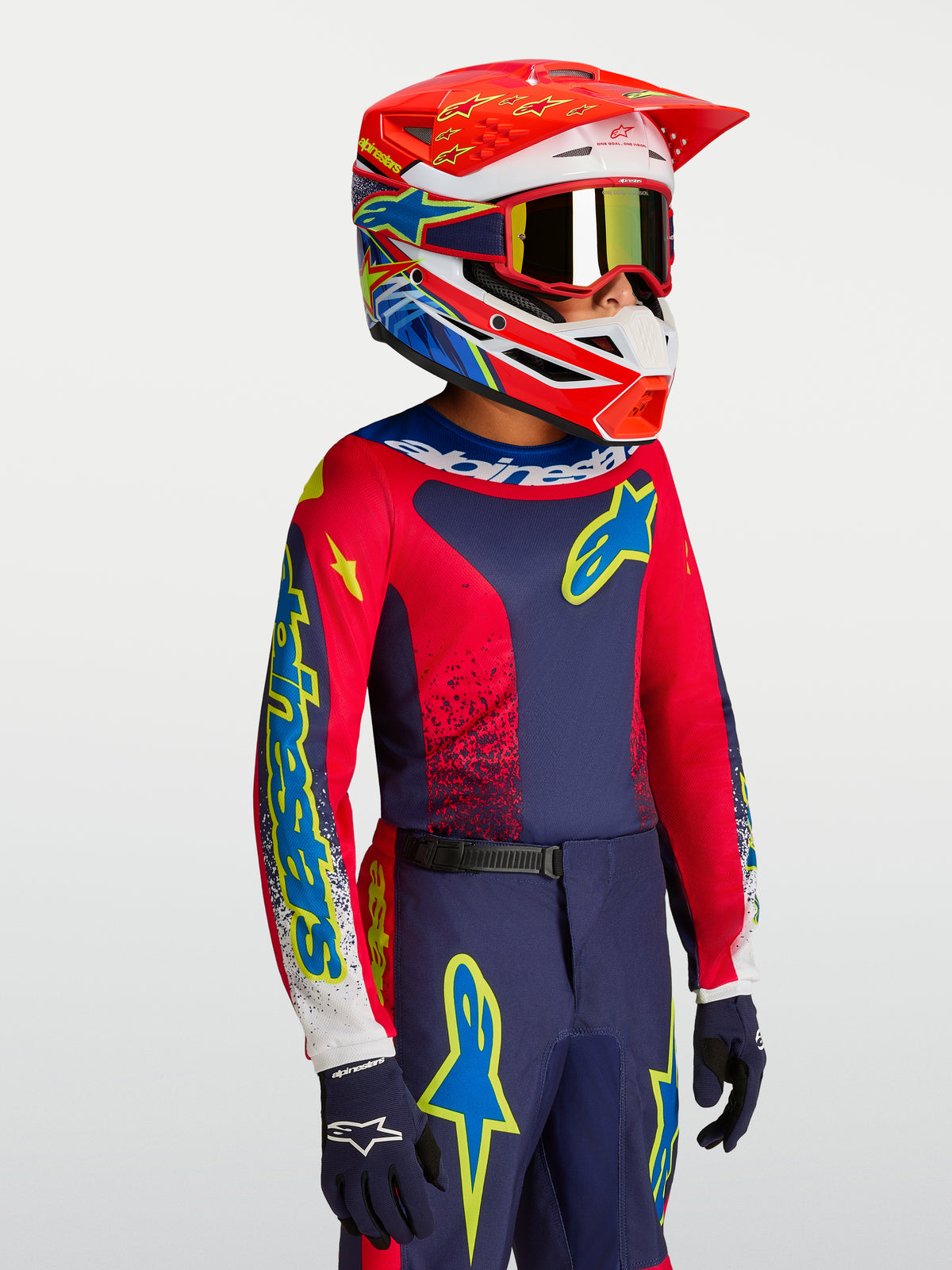 Alpinestars Youth Fluid Drag Jersey, youth motocross gear in Navy Blue and Fire Red with a matching racing helmet.