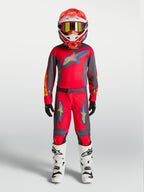 Alpinestars 2027 Fluid Hunt Jugend-Trikot und Gear Set, Motocross-Rennoutfit für Kinder in Rot und Grau, am Model.
