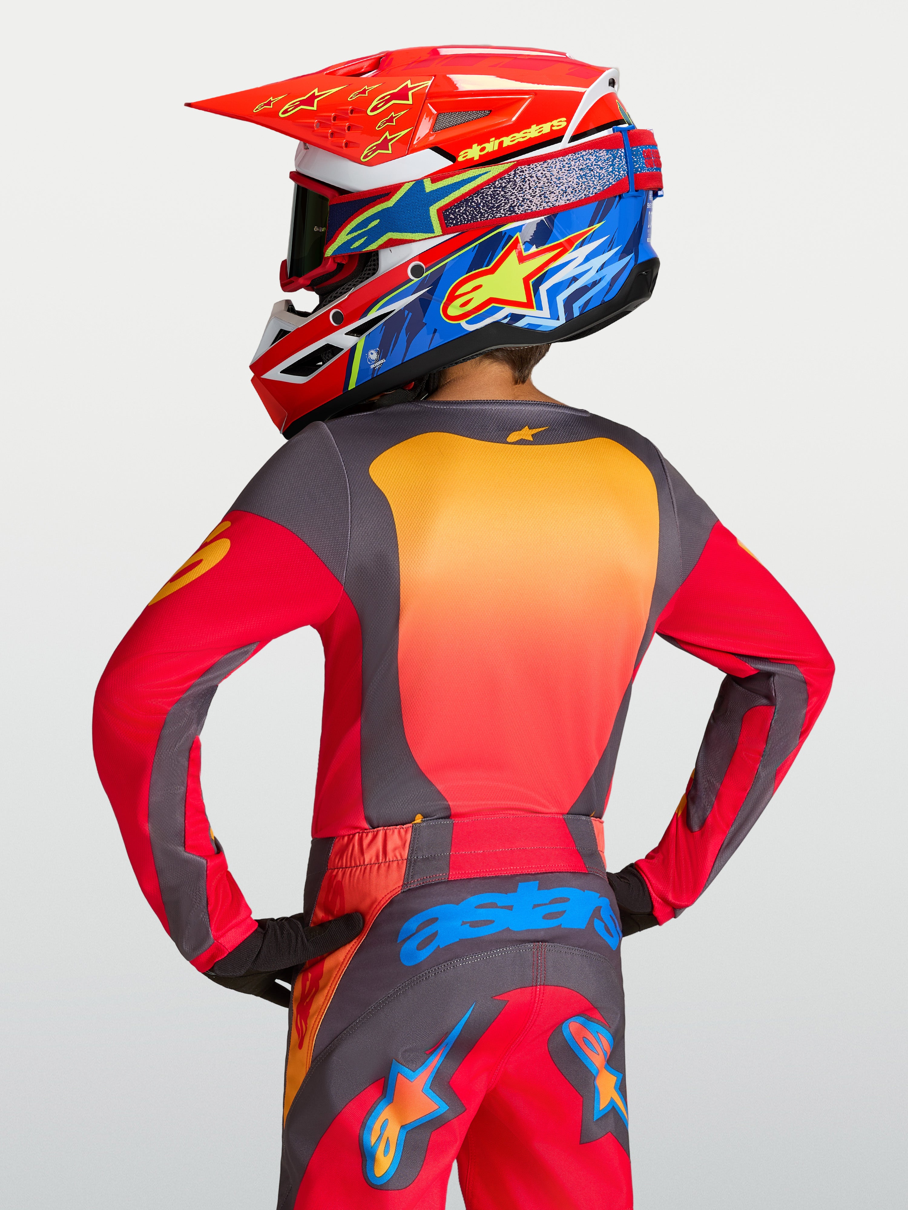 Alpinestars Fluid Hunt Jugend-Trikot, Motocross-Oberteil für Kinder in Rot und Grau, Rückansicht mit orangefarbenen Akzenten, feuchtigkeitsableitendes Polygewebe für den Offroad-Einsatz