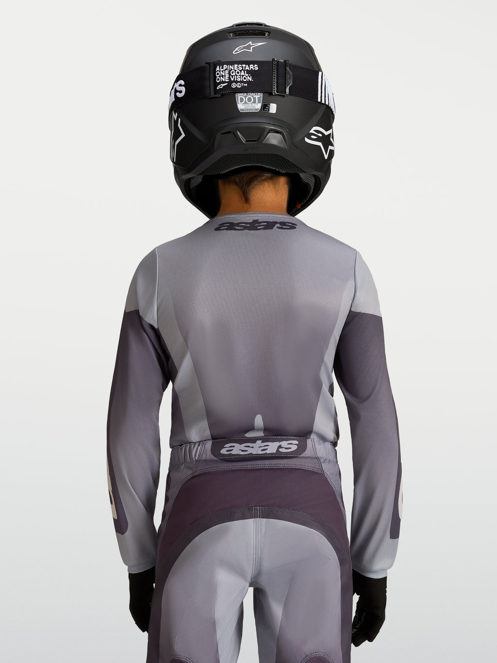 Alpinestars Fluid Jugend-Trikot Amber 2027, Motocross-Trikot für die Jugend, Sand und Grau, atmungsaktives Polygewebe, Rückansicht eines jungen Fahrers mit Helm.