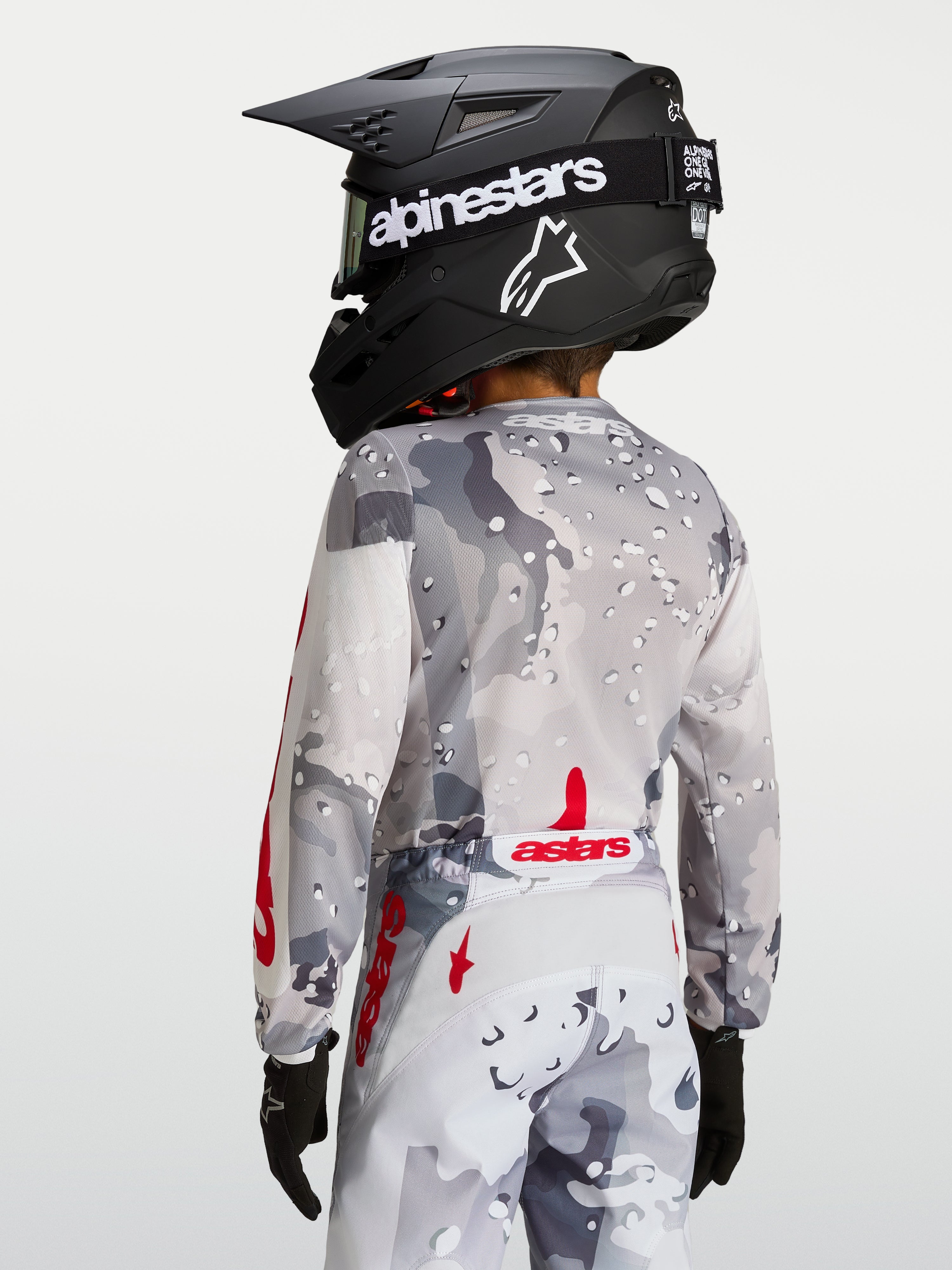 Alpinestars Fluid Jugend-Trikot Lone, Motocross-Oberteil, Grau mit Tarnmuster und Rot, Rückansicht mit ergonomischer Passform und verlängertem hinterem Saum.