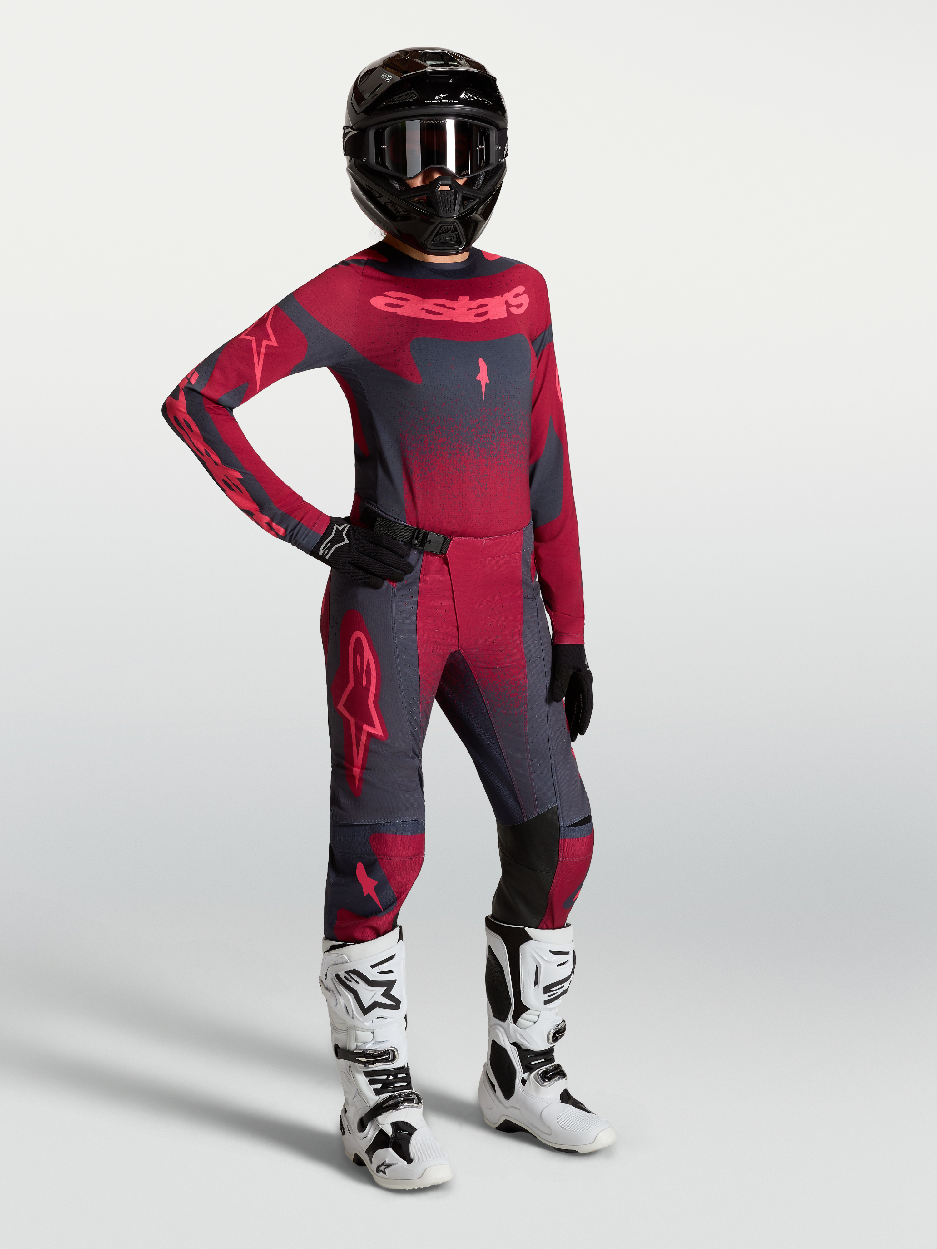 Alpinestars Stella Techstar Swan Hose und Trikot, Damen-Motocross-Outfit in Dunkelrot und Dunkelgrau mit weißen Rennstiefeln.