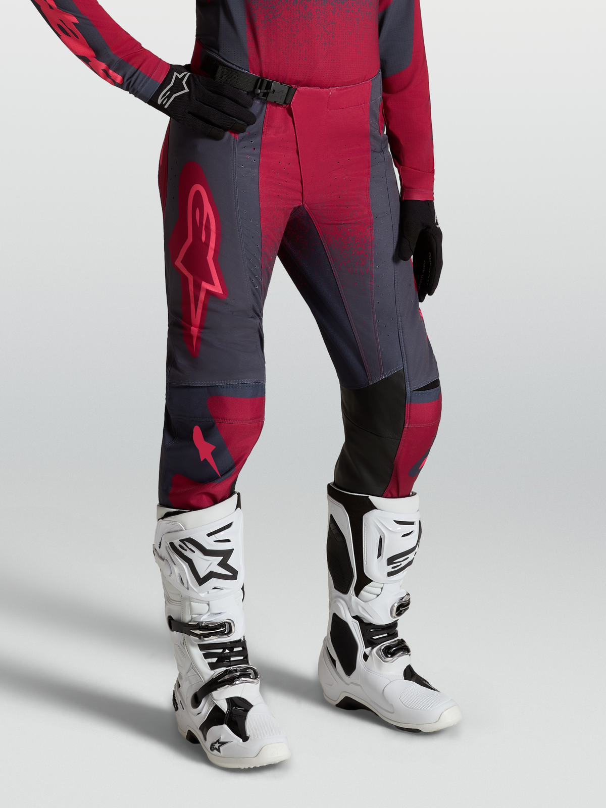 Alpinestars Stella Techstar Swan Damen-Motocross-Hose, Karminrot und Dunkelgrau, kombiniert mit weißen Tech 10 Stiefeln.