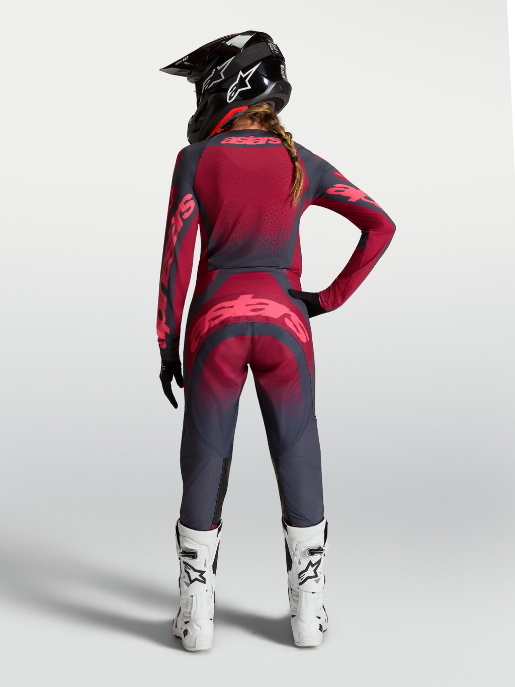 Alpinestars Stella Techstar Trikot Swan, Damen-Motocross-Trikot in Rot und Dunkelgrau, Rückansicht am Model mit Ausrüstung.