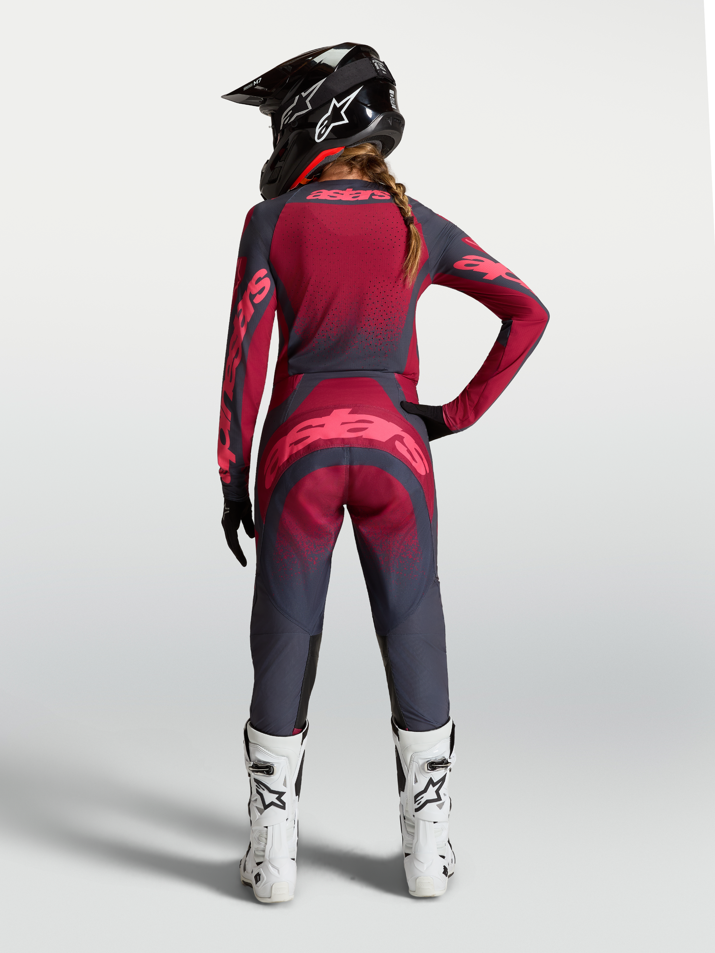 Alpinestars Stella Techstar Trikot Swan, Damen-Motocross-Trikot in Rot und Dunkelgrau, Rückansicht am Model mit Ausrüstung.