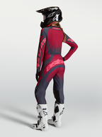Alpinestars Stella Techstar Swan Trikot und Gear Set, Damen-Motocross-Kombi in Rot und Grau, Rückansicht mit Helm.