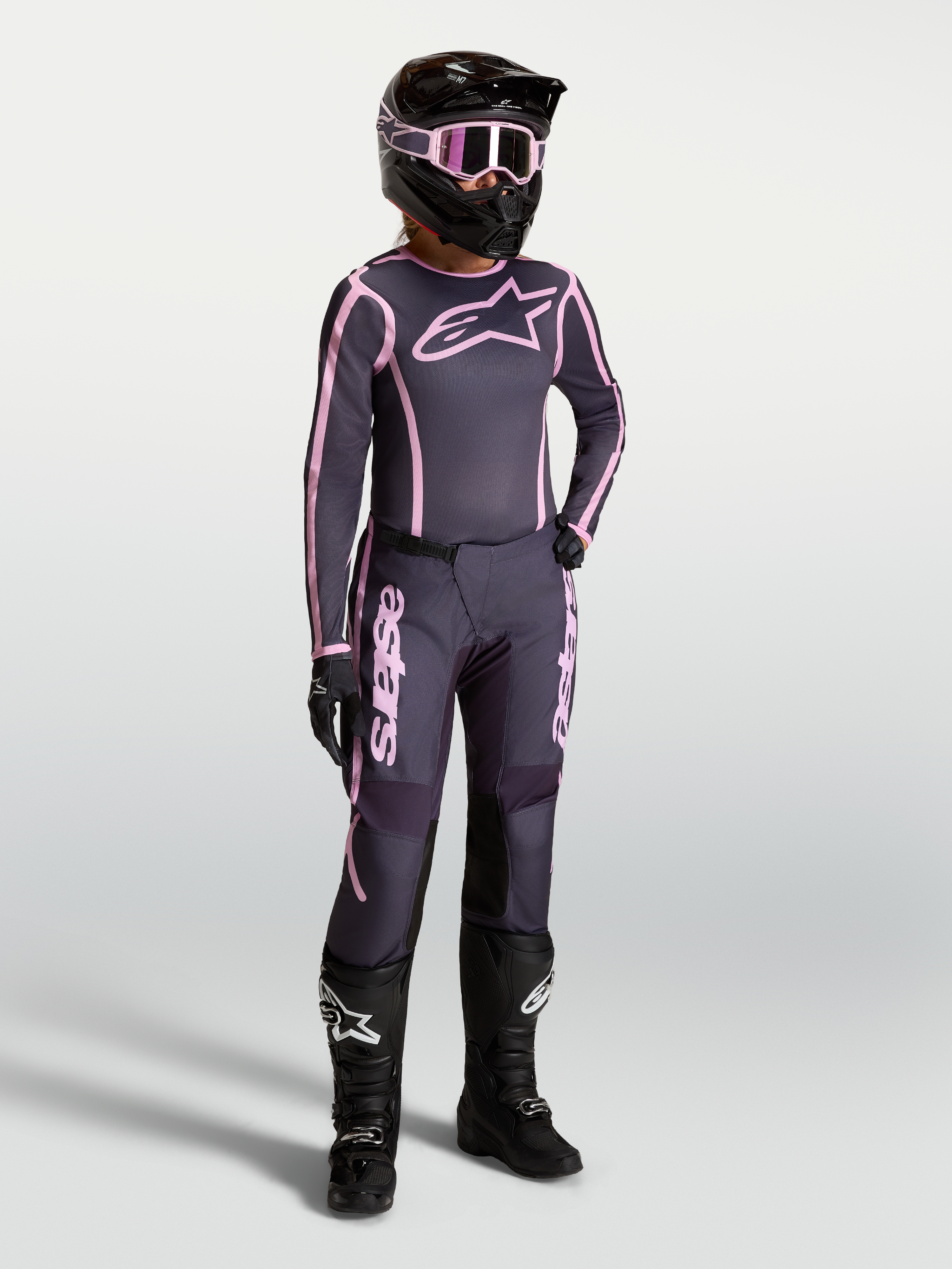 Alpinestars Stella Fluid Apex V2 Trikot und Ausrüstungsset, Damen-Motocross-Kombi in Grau und Pink mit schwarzen Stiefeln.