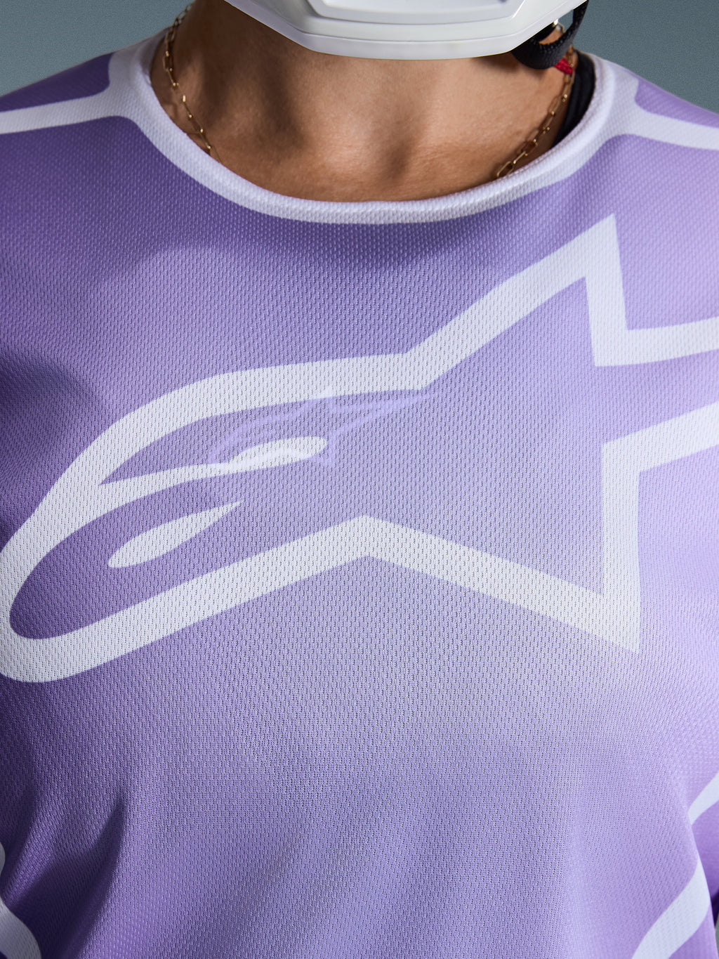Alpinestars 2026 Stella Fluid Apex Trikot, Nahaufnahme der Brust, Lila mit weißen Grafiken, großes weißes Astars-Logo auf Mesh-Polygewebe-Konstruktion.