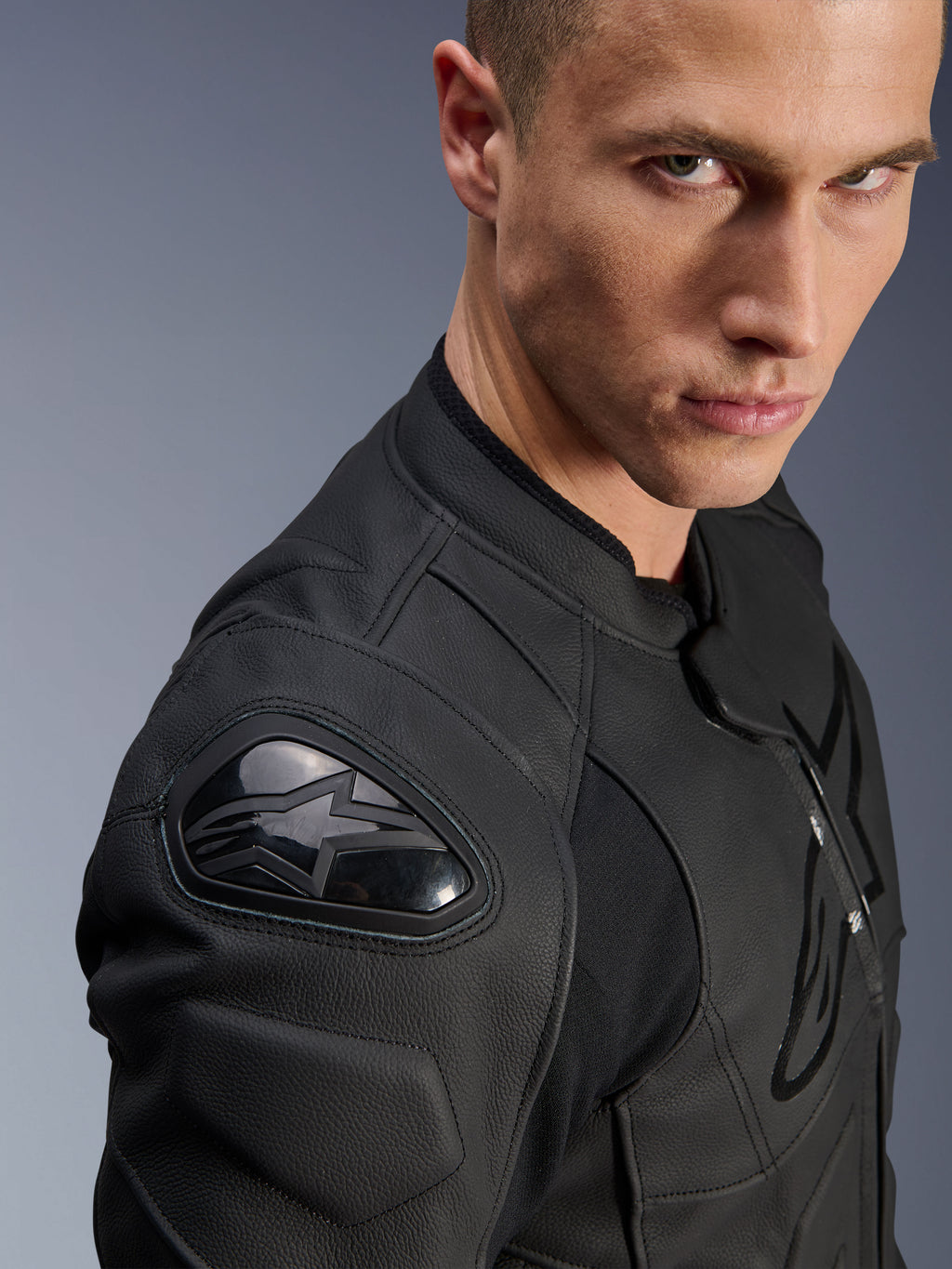 Alpinestars Dusk Lederjacke, Schwarz, Nahaufnahme der Schulter mit externem DFS-Schutz und Alpinestars Stern-Logo, Premium-Rindsleder mit strukturierten Einsätzen, Sport-Motorradausrüstung