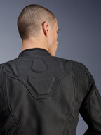 Alpinestars Dusk Lederjacke, Schwarz, Nahaufnahme des oberen Rückens und der Schultern mit dem geprägten DUSK-Logo auf einem gepolsterten Einsatz, Leder-Akkordeon-Stretcheinsätze, Konstruktion aus hochwertigem Rindsleder