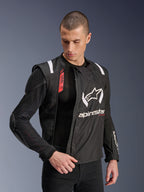 Alpinestars T-Stunt Air Jacke, schwarz-weiße Motorradjacke, getragen von einem männlichen Model, zeigt die modulare Mesh-Konstruktion und sichtbare interne Protektoren an Schulter und Ellbogen, Alpinestars-Branding auf der Brust, Tech-Air® Ready-Funktion, sportlicher Schnitt für den Straßeneinsatz