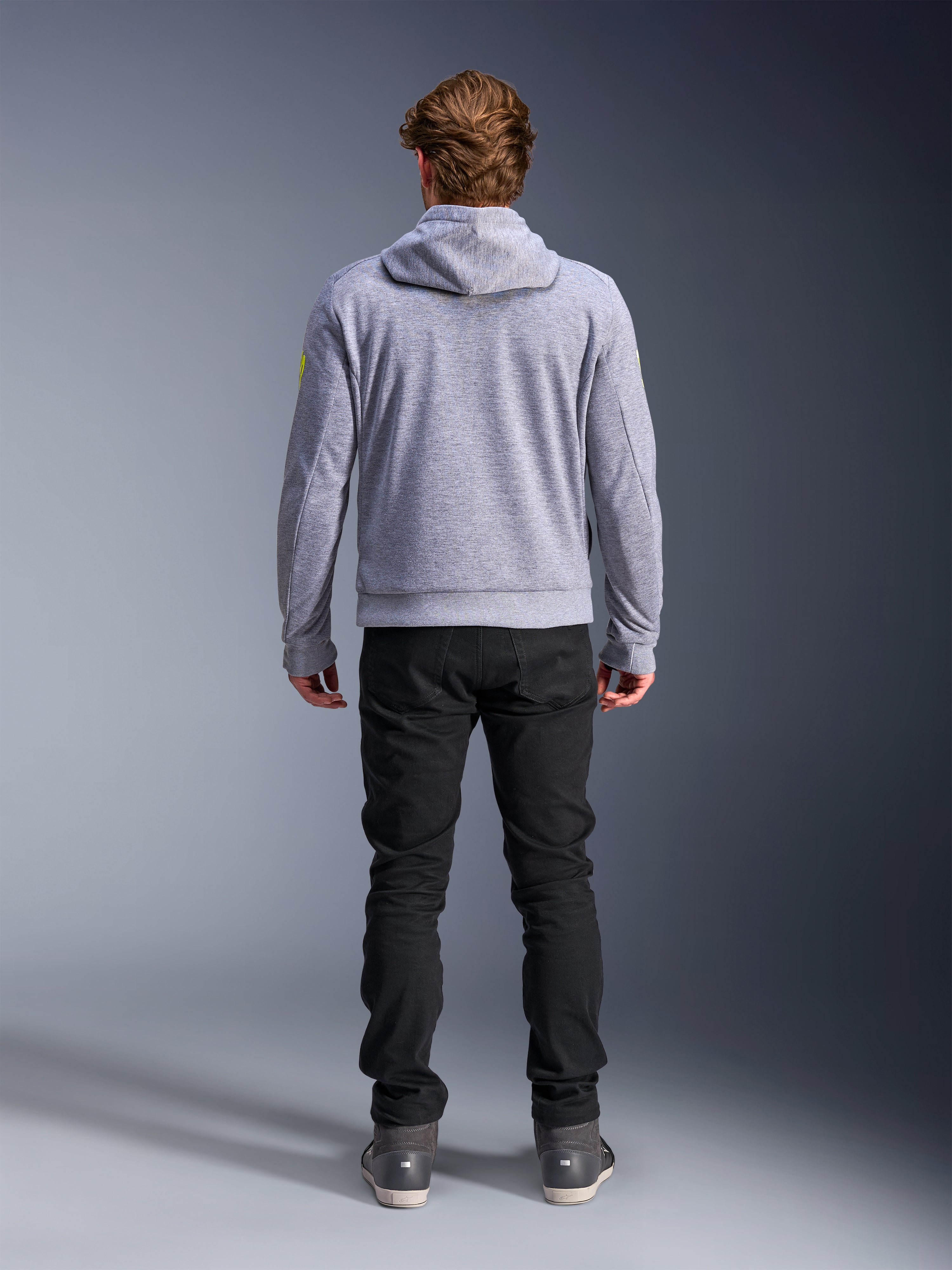 Alpinestars Chrome V2 Sport Hoodie, Gray Heather Fluo Yellow, back view of urban motorcycle riding gear, tech fleece hooded sweatshirt worn with black pants, featuring fluo yellow accents on the sleeves.