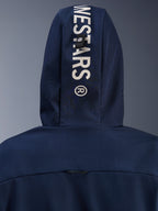 Alpinestars Radium Tech Hoodie in Night Navy Royal Blue, Nahaufnahme der Kapuzenrückseite mit vertikalem weißem Alpinestars-Branding und einem sicheren Befestigungsschlaufen-System, urbane technische Motorradbekleidung.