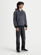 Alpinestars Ageless Kapuzenpullover, urbaner Herren-Motorradhoodie in Asphalt Melange Grau, Vorderansicht an einem Model mit Freizeitbekleidung und CE-zertifizierten Schulter- und Ellbogenprotektoren