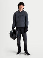 Alpinestars Ageless Kapuzenpullover, urbaner Motorrad-Kapuzenpullover für Herren in Asphalt-Melange-Grau, Frontansicht an einem Model mit schwarzen Motorradhandschuhen, das einen Helm hält, mit integriertem Schulter- und Ellbogenschutz