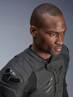 Nahaufnahme eines Models mit der Alpinestars Dusk Airflow Lederjacke, Black on Black, umfangreich perforiertes Leder für Atmungsaktivität, externe DFS-Schulterschleifer, elegantes modernes Design für sportliches Fahren