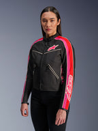 Alpinestars Stella T-Dyno WR Jacke für Damen in Schwarz, Hellrot und Fuchsia, textile Motorradjacke mit Vintage-inspiriertem Biker-Schnitt, fuchsiafarbene und rote Streifen an den Ärmeln, Logo auf der Brust, kombiniert mit einer schwarzen Hose