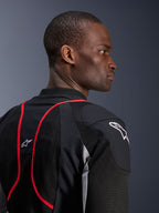 Alpinestars Troop-Air Pro Jacke, technische gepanzerte Air-Jacke, Schwarz, Ash Gray und Bright Red, Nahaufnahme von Profil und Rückenansicht mit Mesh-Textileinsätzen, roten Paspel-Akzenten und weißen Astars-Logos auf der Schulter und dem oberen Rücken