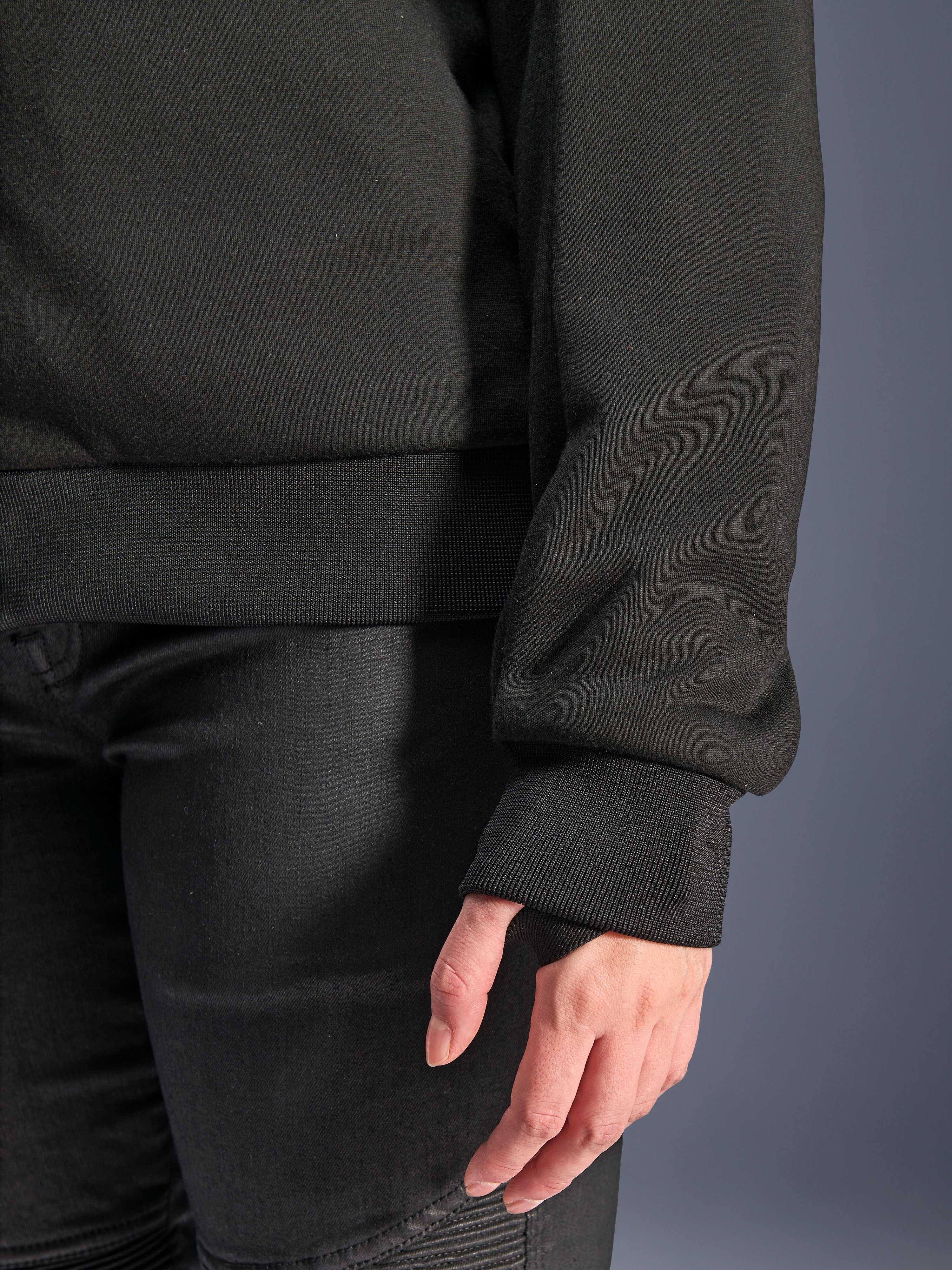 Alpinestars Stella Chrome V2 Sport Hoodie, Schwarz, Nahaufnahme des gerippten Ärmelbündchens mit Daumenloch und des gerippten Taillensaums, Tech-Fleece-Material für urbanes Motorradfahren