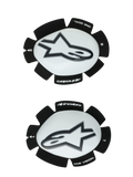 Alpinestars GP Plus Knee Sliders, White and Black, Motorcycle Racing Knee Protectors, pair showing left and right sliders with white plastic surfaces and black Astars logos, scalloped black Velcro backing featuring 'ONE GOAL' and 'ONE VISION' branding