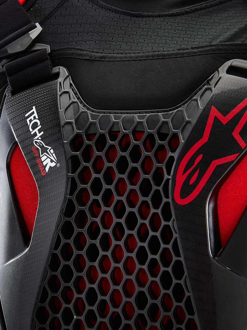Alpinestars Tech-Air Off-Road System, off-road motorcycle airbag system close-up detail, Black and Red, featuring Nucleon CELL honeycomb chest protection, Tech-Air branding, and breathable stretch-mesh chassis