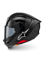 Alpinestars S-R7 Solid Helmet, full-face motorcycle helmet, Black Glossy, left side profile view featuring white Alpinestars logo, aerodynamic shell with integrated spoiler, tinted visor, and red emergency release accents.